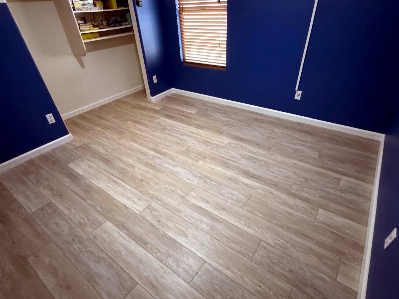 Luxury vinyl plank flooring installed wall-to-wall in a Phoenix-area bedroom